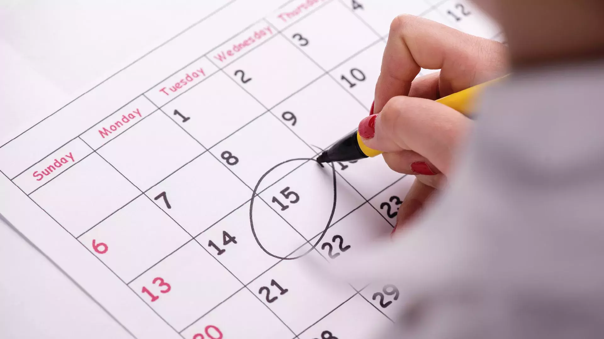calendario, mano che cerchia una data con pennarello