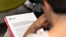 Ragazzo seduto che legge un documento