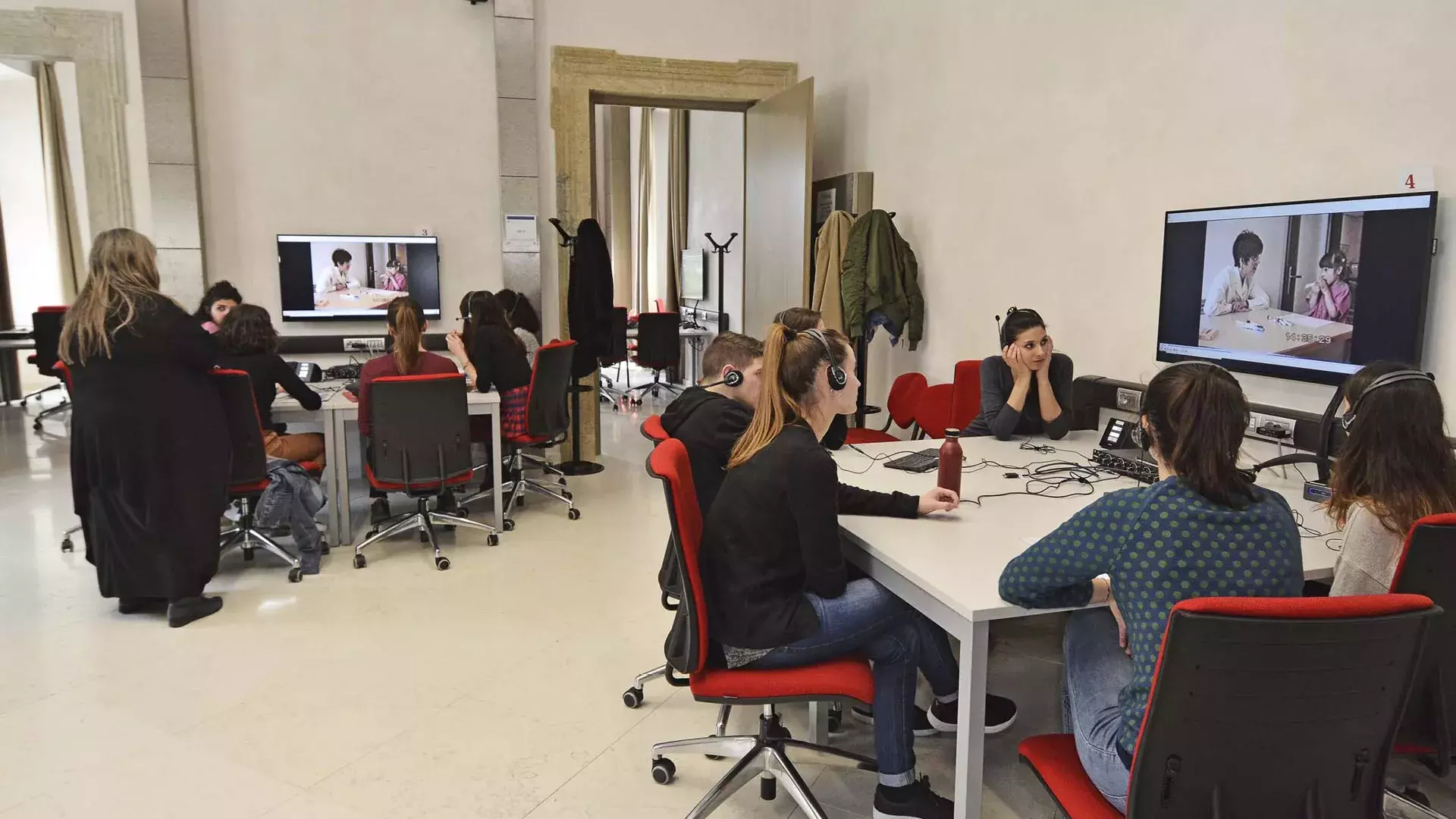 gruppi di studenti in aula, tavoli di lavoro, schermi